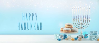 Mutlu Hanukkah. Menorah, donutlar, dreidels ve hediyeler beyaz masada, afiş tasarımı