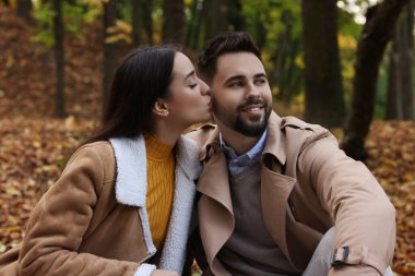 Mutlu genç çift sonbahar parkında birlikte vakit geçiriyor.