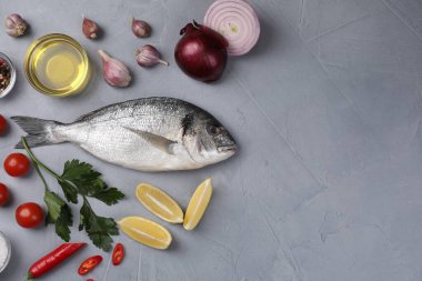 Çiğ dorado balığı ve sebzelerle bezenmiş düz bir kompozisyon. Metin için boşluk