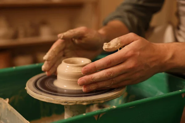 Clay crafting. Man making bowl on potter's wheel indoors, closeup