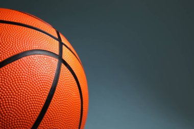 Koyu gri arka planda turuncu bir basketbol topu, yakın plan. Metin için boşluk