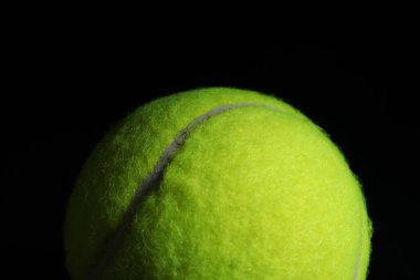 Siyah arka planda bir tenis topu, yakın plan.