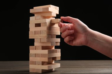 Masada siyah arka planda Jenga oynayan kadın, yakın plan