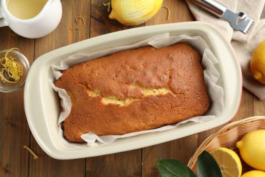 Lezzetli limonlu kek ve ahşap masada narenciye meyveleri, düz yatıyordu.
