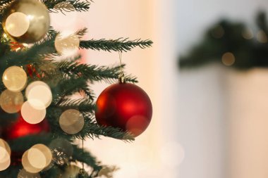 Işıklı arka planda şenlikli toplarla süslenmiş Noel ağacı, yakın plan. Metin için boşluk