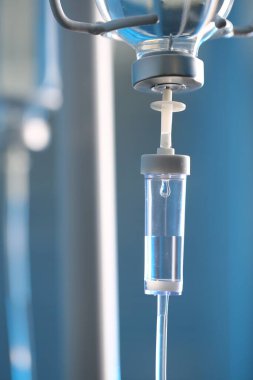 Bulanık ışık arkaplanına karşı serum damlası