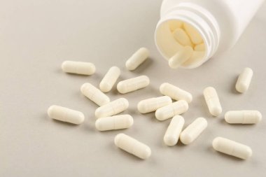 Işık arkaplanındaki şişe ve vitamin kapsülleri, yakın plan