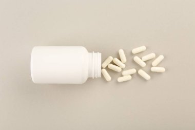 Işık arkaplanındaki şişe ve vitamin kapsülleri, üst görünüm
