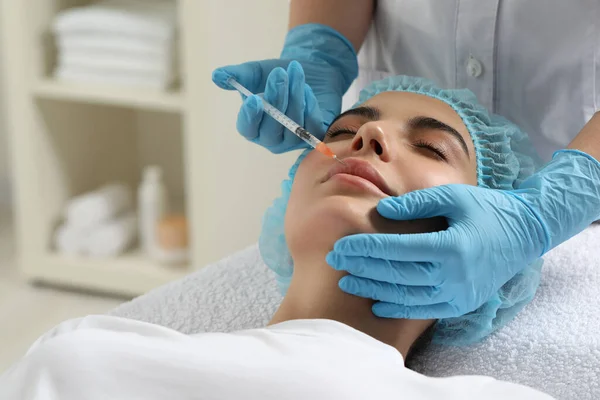 stock image Doctor giving lips injection to young woman in clinic. Cosmetic surgery