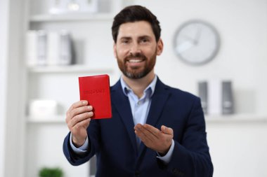 Göçmen bürosu. Pasaportu içeride, seçici odaklı mutlu bir adam.