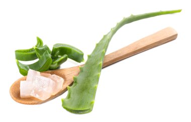 Aloe vera jeli kaşıkta ve beyaza izole edilmiş bitki dilimleri
