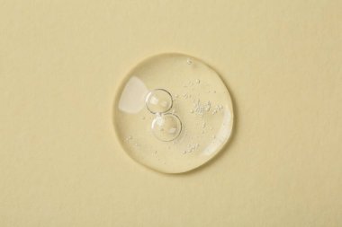 Bej arka planda kozmetik serumu örneği, üst görünüm