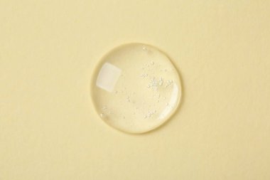 Bej arka planda kozmetik serumu örneği, üst görünüm