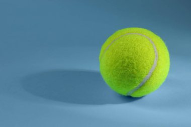 Açık mavi arka planda bir tenis topu, metin için boşluk