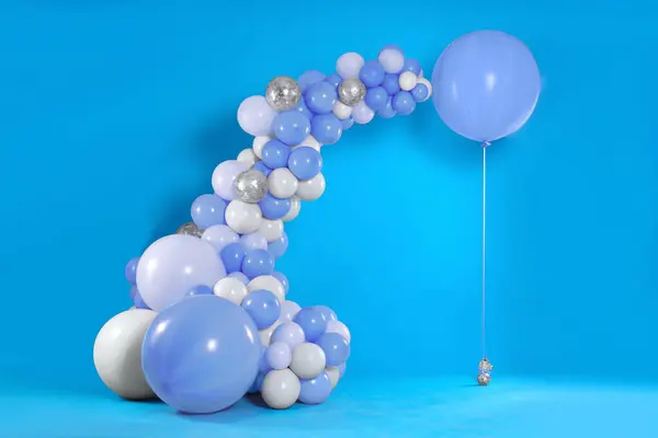 Balloon garland near light blue wall. Festive decor