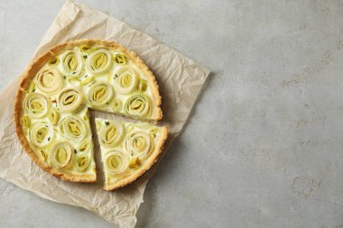 Gri desenli masa üzerinde leziz pırasalı turta, üst manzara. Metin için boşluk