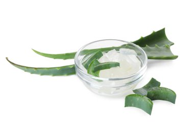 Kabuktaki kabuklu aloe vera ve beyaza izole edilmiş yeşil bitki parçaları.