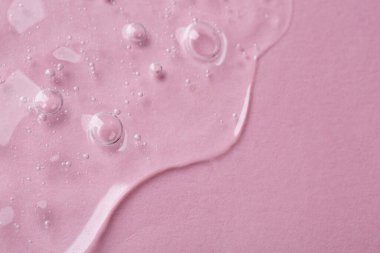 Pembe arka planda kozmetik serumu, üst manzara. Metin için boşluk