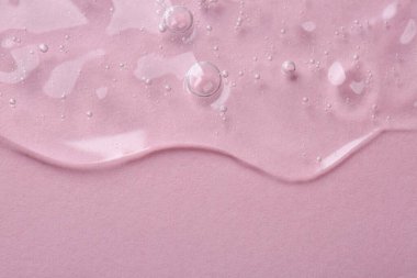 Pembe arka planda kozmetik serumu, üst manzara. Metin için boşluk