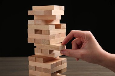 Masada siyah arka planda Jenga oynayan kadın, yakın plan