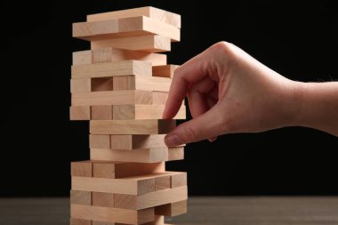 Masada siyah arka planda Jenga oynayan kadın, yakın plan