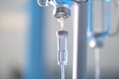 Bulanık ışık arkaplanına karşı serum damlası