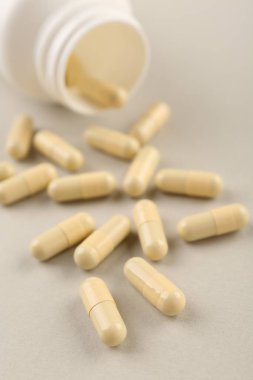 Işık arkaplanındaki şişe ve vitamin kapsülleri, yakın plan