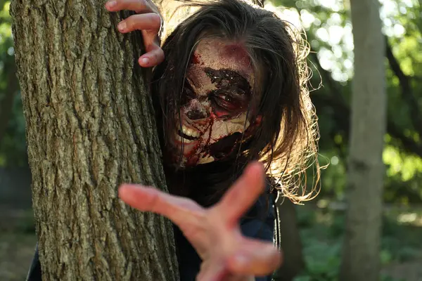 Ağacın yanındaki korkunç zombi. Cadılar Bayramı canavarı
