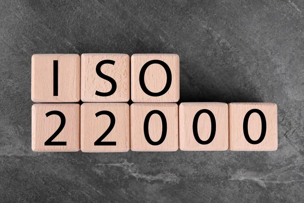 International Organization for Standardization. Cubes with abbreviation ISO 22000 on gray textured table, top view