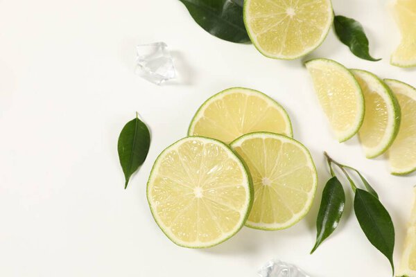 Кусочки, лед и зеленые листья на белом фоне, вид сверху. Пространство для текста