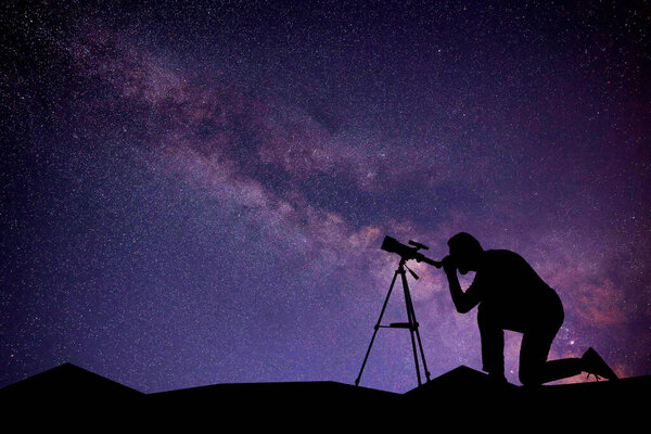 Astronomer looking at starry sky through telescope outdoors. Space for text