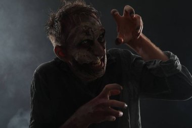 Karanlık arka planda korkunç bir zombi. Cadılar Bayramı canavarı