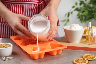 Gri taş masada doğal el yapımı sabun yapan kadın, yakın plan.