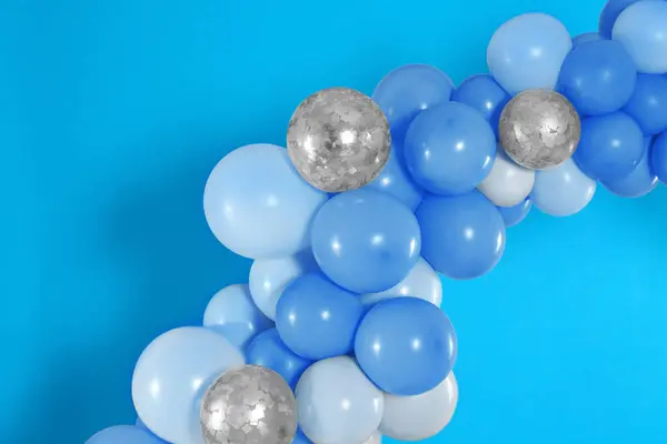 Balloon garland on light blue background. Festive decor
