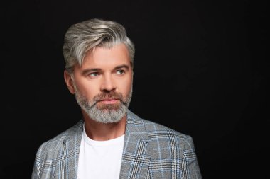 Siyah arka planda güzel saç stili olan kendine güvenen bir adamın portresi. Metin için boşluk