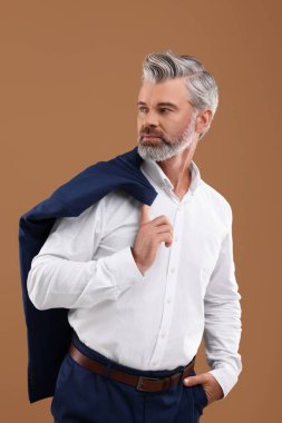 Açık kahverengi arka planda güzel saç stili olan kendinden emin bir adamın portresi.