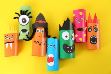 Sarı arka planda komik canavarlar, düz yerde yatıyorlar. Cadılar Bayramı dekorasyonu