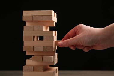 Masada siyah arka planda Jenga oynayan kadın, yakın plan