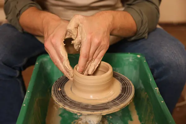 Clay crafting. Man making bowl on potter\'s wheel, closeup