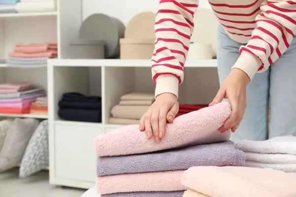 Woman choosing towels in home textiles store, closeup. Space for text