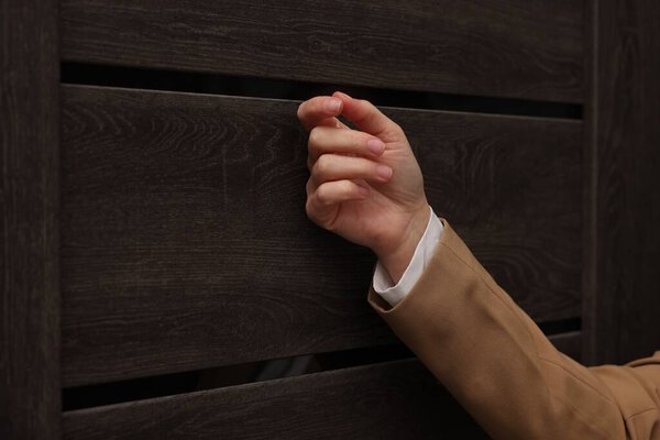 Collector knocking on door indoors, closeup view