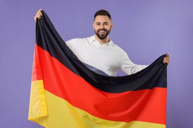 Mor arka planda Almanya bayrağı taşıyan genç adam