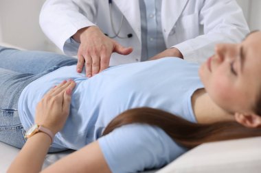 Gastroenterolog klinikte mide ağrısı olan hastayı muayene ediyor.
