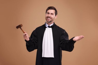 Kahverengi arka planda tokmağı olan gülümseyen yargıç.