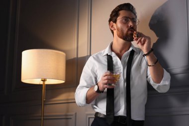 Evde puro içen yakışıklı bir adam. Düşük açılı.