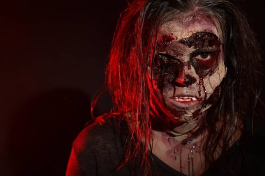 Karanlık arka planda korkunç bir zombi, yakın plan. Cadılar Bayramı canavarı