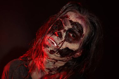 Karanlık arka planda korkunç bir zombi, yakın plan. Cadılar Bayramı canavarı