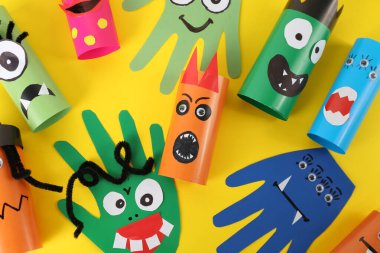 Sarı arka planda komik canavarlar, düz yerde yatıyorlar. Cadılar Bayramı dekorasyonu