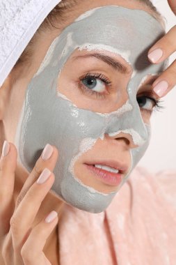 Beyaz arka planda yüz maskesi olan kadın, yakın plan. Spa tedavileri