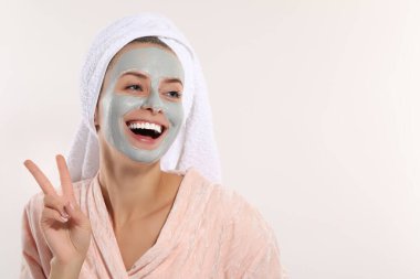 Yüz maskeli kadın beyaz arka planda Ziyaretçi işareti gösteriyor, mesaj için yer var. Spa tedavileri